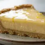 Simple Lemon Pie with Condensed Milk: The Best Dessert! 7 Lemon Pie with Condensed Milk slice on speckled ceramic plate showing creamy yellow filling, graham cracker crust, and glossy lemon curd topping