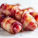 Bacon Wrapped Little Smokies: A Crowd-Pleaser! 7 Bacon wrapped little smokies baked until crispy and glazed, served on a platter