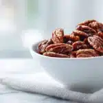 Easy Candied Pecans Recipe 7 Candied pecans coated in caramelized sugar and spices, glossy and crunchy in a bowl