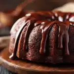 Chocolate swirl mousse Bundt cake with glossy chocolate drizzle and soft marbled interior on a cake stand
