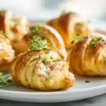 Crab crescent bites baked until golden with creamy crab filling on a platter