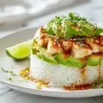 Tangy Honey Lime Chicken and Avocado Rice Stack 7 Honey lime chicken layered with avocado rice and fresh toppings in a neat stack on a plate