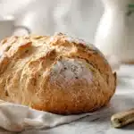 Traditional Irish soda bread with golden crust and rustic scoring on a loaf