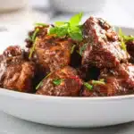 Jamaican Brown Stew Chicken 7 Jamaican brown stew chicken simmered in rich gravy with onions, peppers, and herbs in a bowl