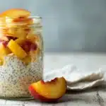 Low calorie overnight oats topped with fresh fruit in a glass jar.