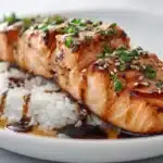 Salmon teriyaki glazed with thick teriyaki sauce, garnished with sesame seeds and green onions