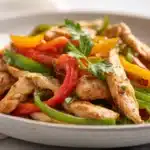 Air fryer chicken fajitas with seasoned chicken strips, bell peppers, and onions