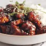 Air fryer teriyaki chicken glazed and caramelized, sliced and served with sesame seeds and green onions.