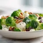 Easy Broccoli Salad 7 Fresh broccoli salad with crisp florets, bacon bits, dried cranberries, sunflower seeds, and creamy dressing in a bowl.