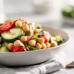 Chickpea Salad 7 Chickpea salad with tender chickpeas, diced vegetables, fresh herbs, and light vinaigrette mixed in a bowl.