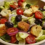 Copycat Olive Garden Salad 7 Copycat Olive Garden salad with crisp romaine, tomatoes, red onion, olives, pepperoncini, croutons, and creamy Italian dressing in a large bowl.