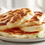 Irish potato farls cooked until golden, cut into triangles, and served on a plate