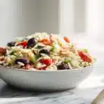 Orzo Salad 7 Colorful orzo salad with tender pasta, cherry tomatoes, cucumber, herbs, and feta tossed in a light vinaigrette.