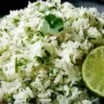 Fluffy cilantro lime rice garnished with fresh chopped cilantro and lime wedges in a bowl