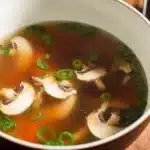 Japanese Clear Soup 6 Japanese clear soup with mushrooms, carrots, and green onions in a light, golden broth, served in a traditional bowl.