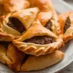 Lebanese meat pies (Sfeehas) made with soft golden dough topped with seasoned ground beef, onions, and spices