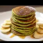 Spinach banana pancakes green and fluffy stacked on a plate
