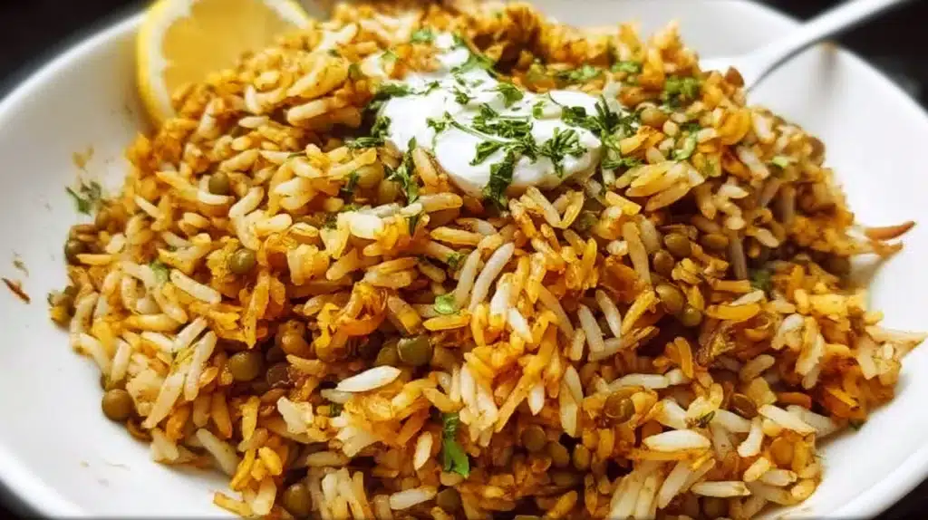 Lentils and rice served in a bowl with spices and herbs on top.